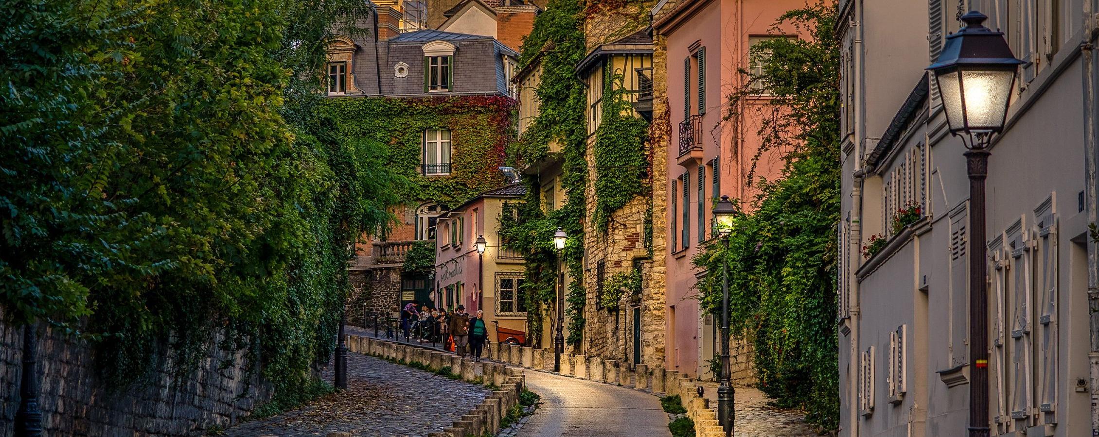 Streets of a European city with vines growing on the buildings.